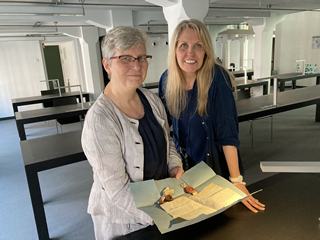 Philippa and Henrike holding ancient documents